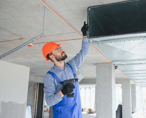 Side view of HVAC technician doing maintenance